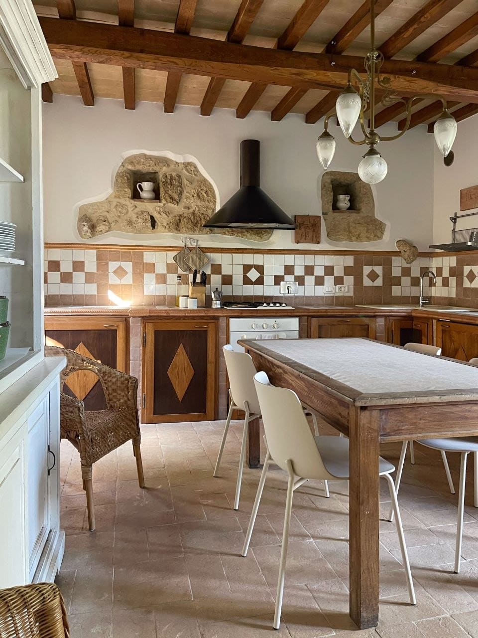 La cucina con le nicchie in pietra e il lampadario d'ottone