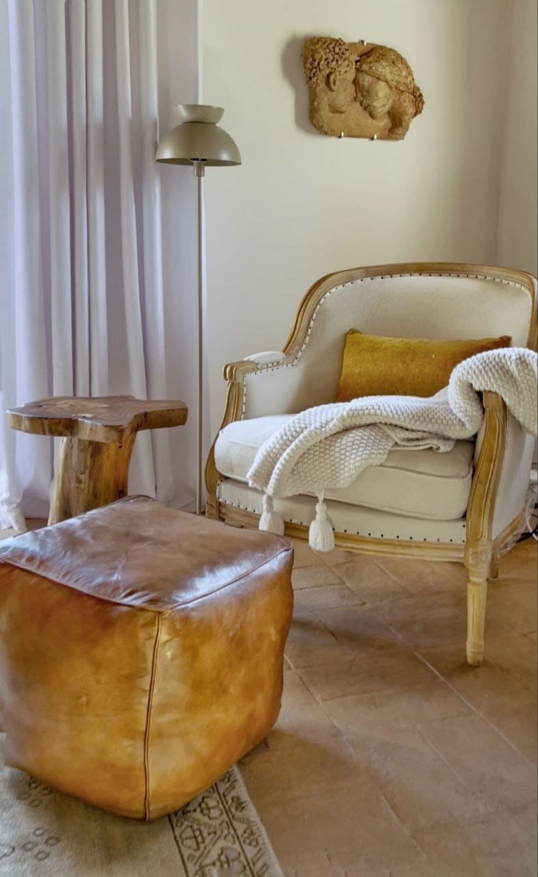 L'angolo lettura con poltrona bergère e pouf in cuoio