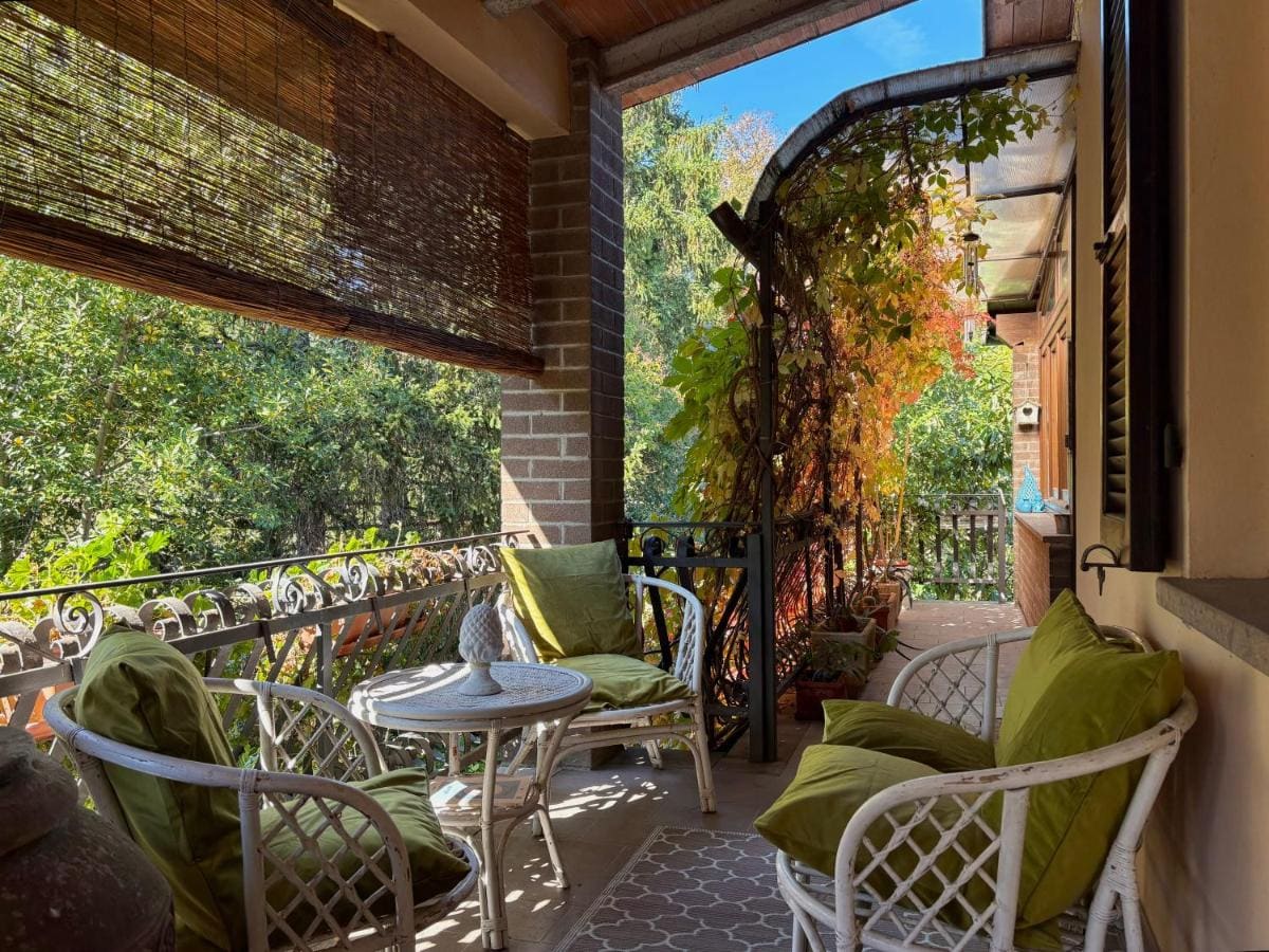 La veranda con poltrone di vimini e rampicanti de La Casa delle Ortensie