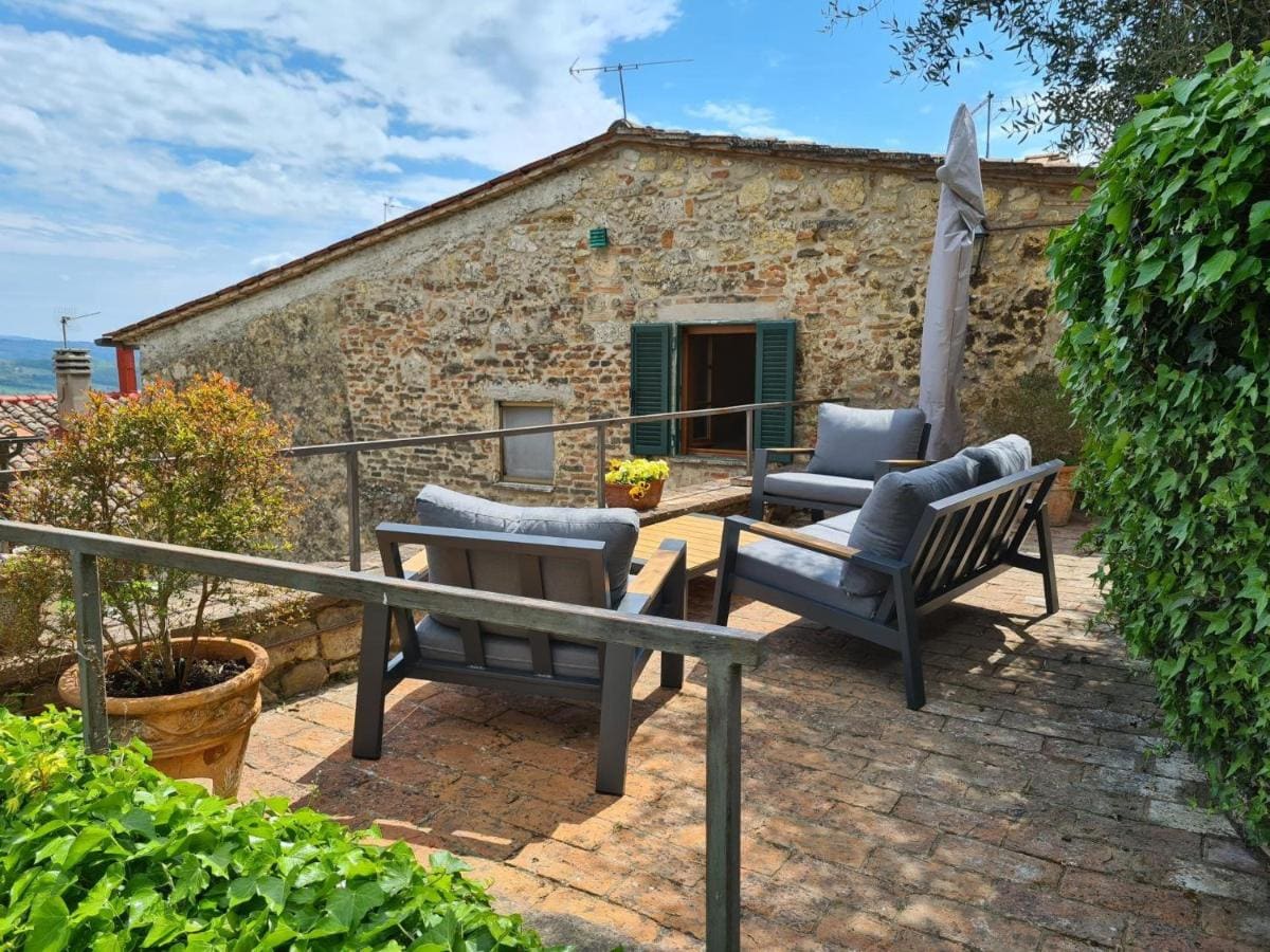La terrazza in cotto con salotto esterno, l'ulivo e la vista sulla valle di Cetona